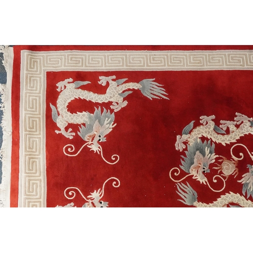 1071 - Chinese red and cream carpet decorated with dragons chasing the flaming pearl and Greek key border, ... 