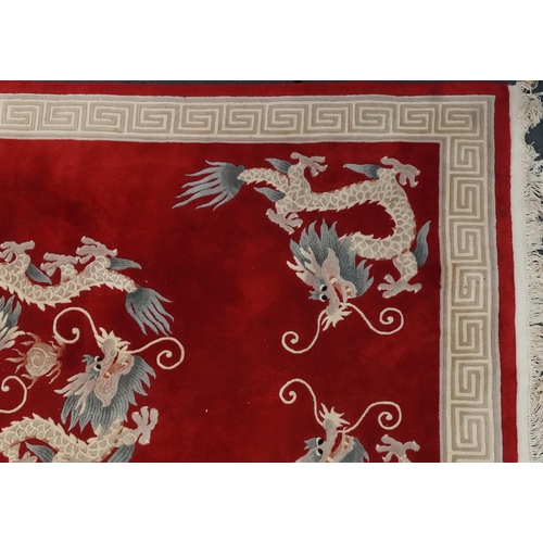 1071 - Chinese red and cream carpet decorated with dragons chasing the flaming pearl and Greek key border, ... 