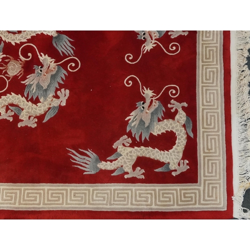 1071 - Chinese red and cream carpet decorated with dragons chasing the flaming pearl and Greek key border, ... 