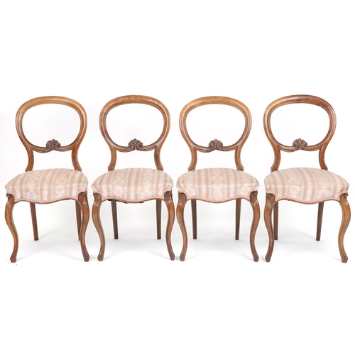 1035 - Set of four Victorian walnut spoon back dining chairs with salmon floral upholstered seats, 87cm hig... 