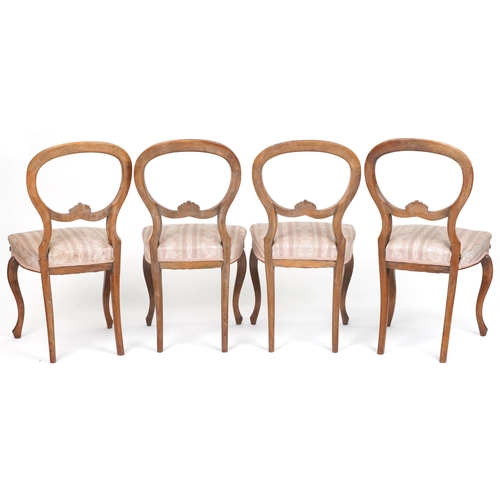 1035 - Set of four Victorian walnut spoon back dining chairs with salmon floral upholstered seats, 87cm hig... 