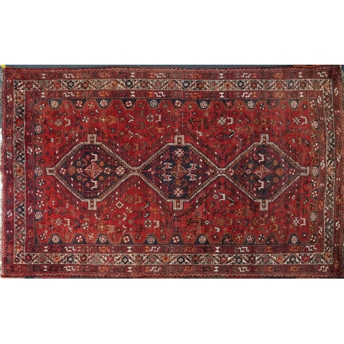 1003 - Persian red and blue ground carpet having an allover geometric and animal design, 295cm x 214cm