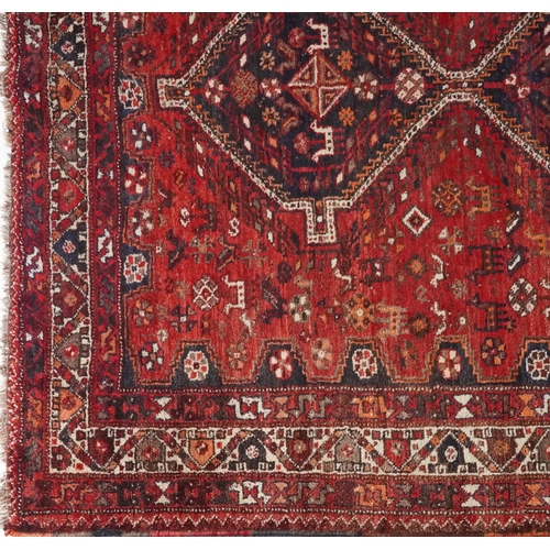 1003 - Persian red and blue ground carpet having an allover geometric and animal design, 295cm x 214cm