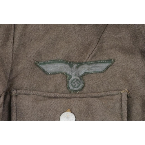 496 - German military interest tunic with cloth badge