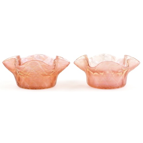 1153 - Pair of Stuart and Son's gilt and peach glass finger bowls, each 14cm in diameter