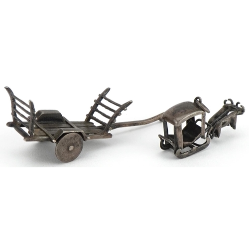 1179 - Asian unmarked silver miniature cart and a buffalo drawn cart charm, the largest 5.5cm in length, to... 