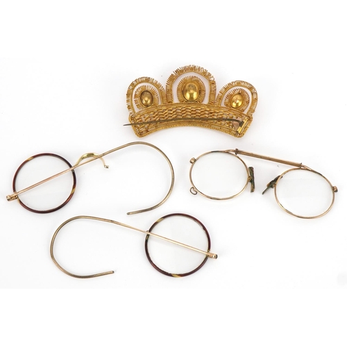 1273 - Two pairs of antique yellow metal spectacles and a yellow metal crown brooch set with orange stones,... 