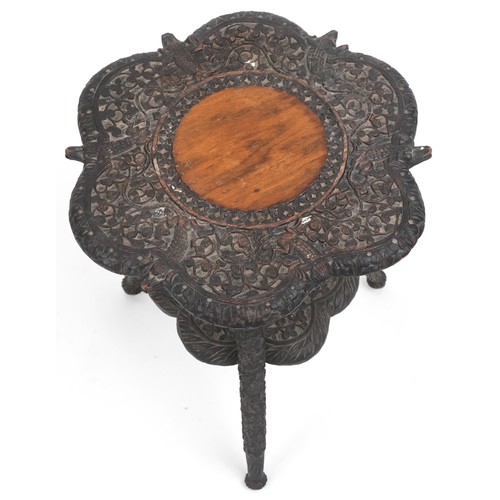 1076 - Anglo Indian ebonised occasional table with undertier profusely carved with crocodiles amongst folia... 