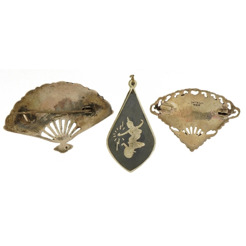 2628 - Two Thai Siam fan brooches with niello work dancers and a similar pendant, the largest 5.5cm wide, t... 