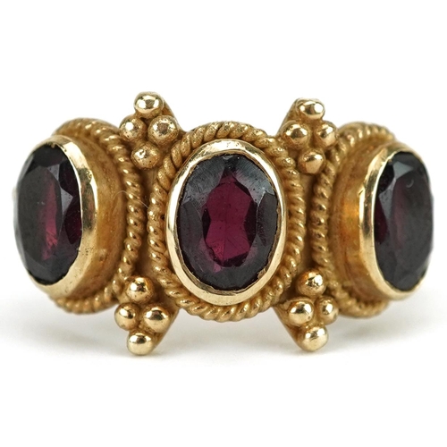 2188 - Victorian style garnet three stone ring with cast setting, size M, 3.9g