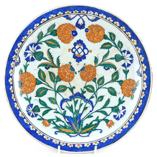 145 - Turkish Ottoman Iznik footed plate hand painted with stylised flowers, 30cm in diameter