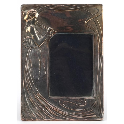 62 - Elizabeth II rectangular silver easel photo frame embossed with an Art Nouveau female playing a musi... 