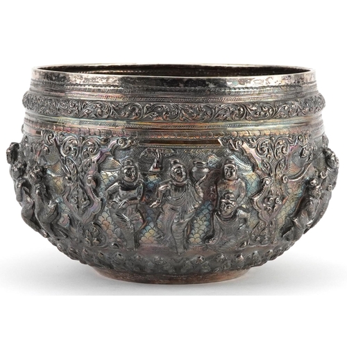  Burmese unmarked silver bowl profusely embossed with deities and animals within landscapes, 12cm hig... 