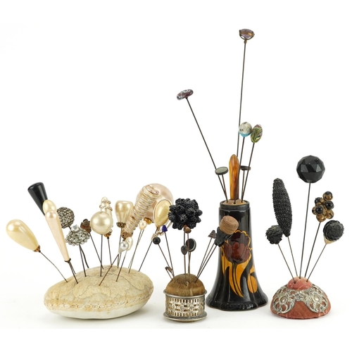 293 - Collection of early 20th century and later hatpins arranged in four hatpin stands including two silv... 