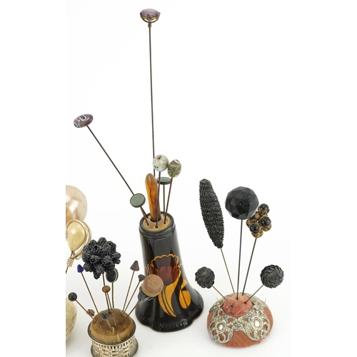 293 - Collection of early 20th century and later hatpins arranged in four hatpin stands including two silv... 