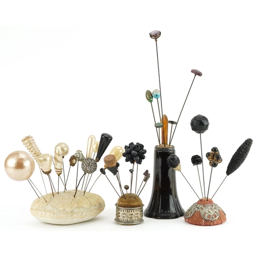 293 - Collection of early 20th century and later hatpins arranged in four hatpin stands including two silv... 