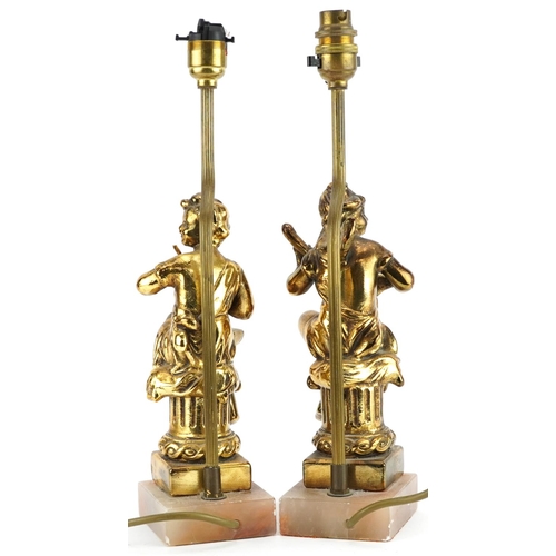 1303 - Pair of classical gilt painted, brass and onyx table lamps, each in the form of musicians seated on ... 