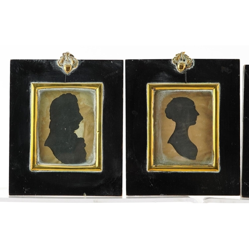 243 - Four Georgian hand painted silhouette portrait miniatures housed in ebonised framed with brass mount... 