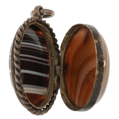 2569 - Unmarked silver locket set with two Scottish agate cabachons, 3.5cm high, 16.4g