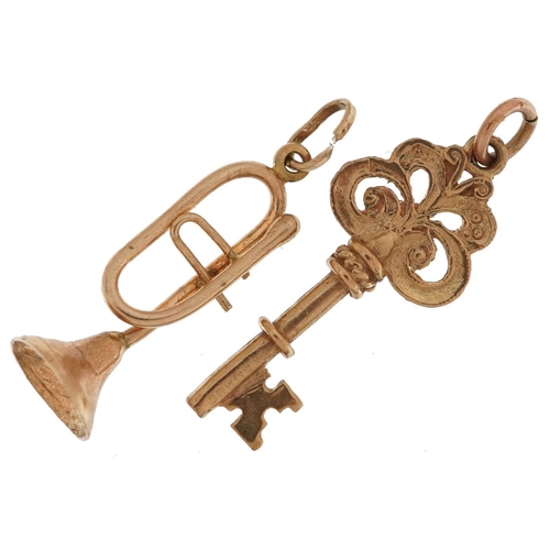 2556 - Two 9ct gold charms comprising trumpet and a key, the largest 2.5cm high, total 2.1g