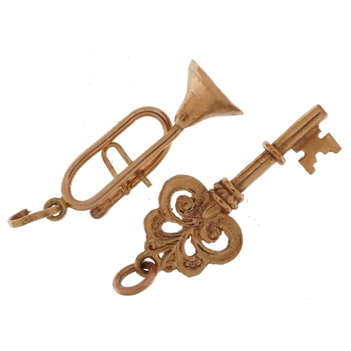 2556 - Two 9ct gold charms comprising trumpet and a key, the largest 2.5cm high, total 2.1g