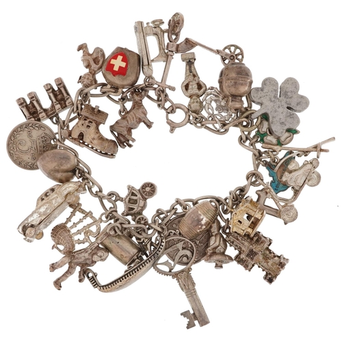 2466 - Silver charm bracelet with a large collection of silver charms including scooter, sewing machine, cl... 