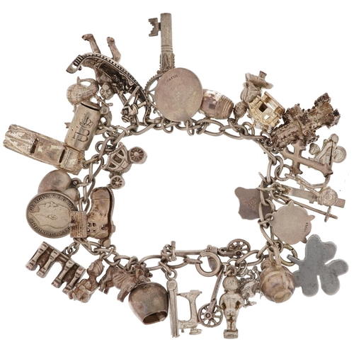 2466 - Silver charm bracelet with a large collection of silver charms including scooter, sewing machine, cl... 