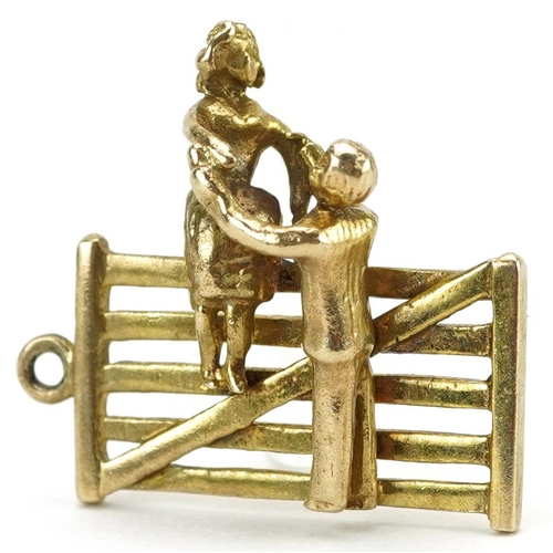 2130 - 9ct gold charm in the form of a gentleman helping a lady down from a gate, 2.1cm high, 4.2g