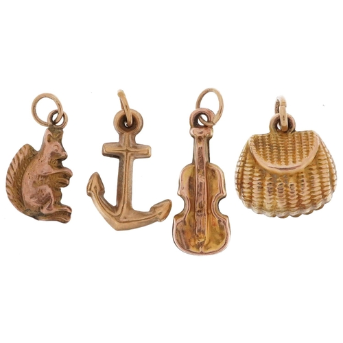 2447 - Three 9ct gold charms in the form of an anchor, squirrel and violin and a yellow metal shell shaped ... 