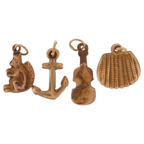 2447 - Three 9ct gold charms in the form of an anchor, squirrel and violin and a yellow metal shell shaped ... 