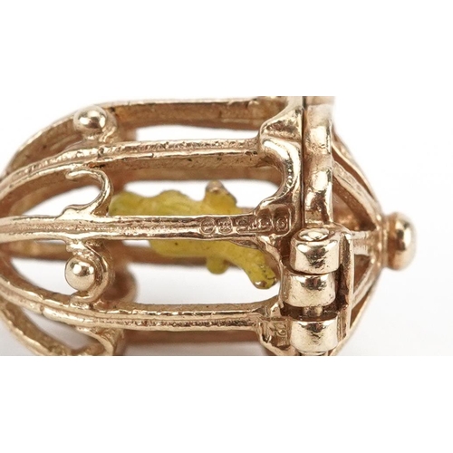 2073 - 9ct gold and enamel opening charm in the form of a bird in a cage, 2.2cm high, 3.6g