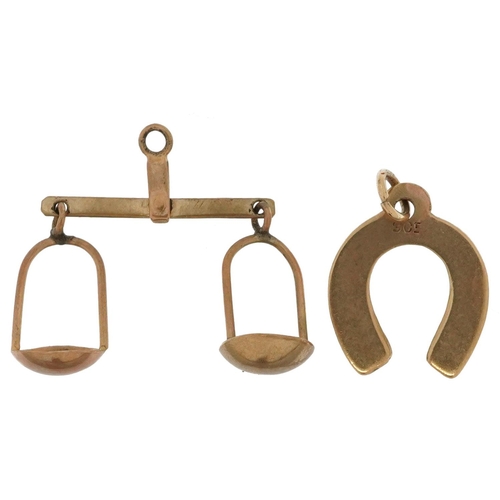 2599 - Two 9ct gold charms comprising balance scales and lucky horseshoe, the largest 2.3cm wide, total 1.1... 