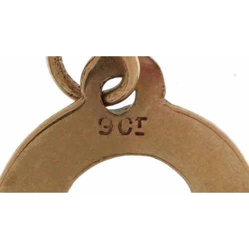 2599 - Two 9ct gold charms comprising balance scales and lucky horseshoe, the largest 2.3cm wide, total 1.1... 