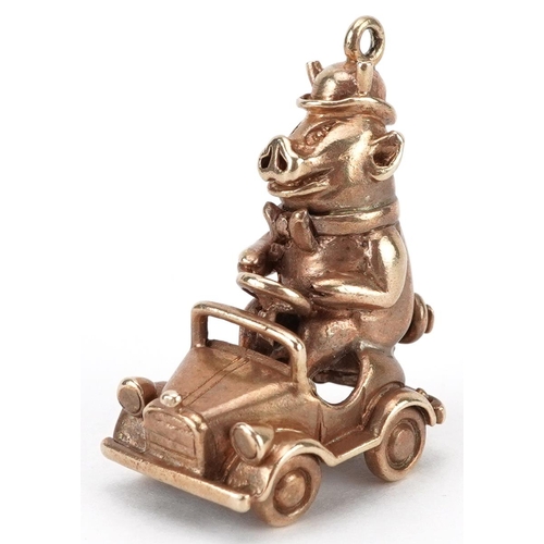 2057 - 9ct gold charm in the form of a comical pig driving a car, 2.8cm high, 8.5g