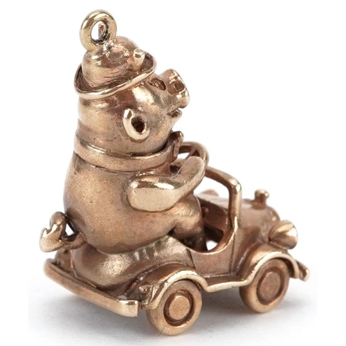 2057 - 9ct gold charm in the form of a comical pig driving a car, 2.8cm high, 8.5g