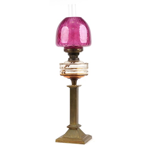 188 - Victorian brass oil lamp with reeded column and cranberry glass shade, 73cm high