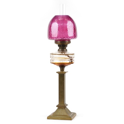 188 - Victorian brass oil lamp with reeded column and cranberry glass shade, 73cm high