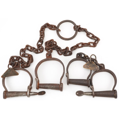 292 - Two pairs of 19th century cast iron handcuffs with tags engraved Abbeville 1844 Daddy Toby no 88 and... 