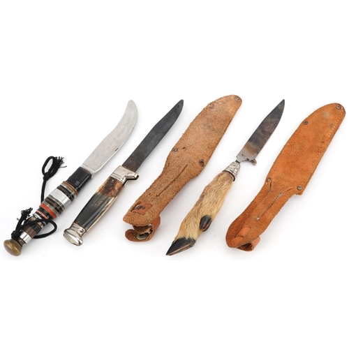 672 - Three vintage hunting knives including a taxidermy example with deer's foot, two with leather sheath... 