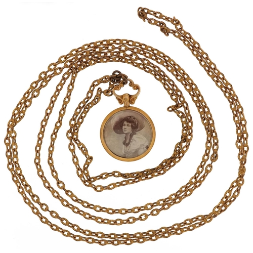 2244 - 9ct gold circular open locket on a yellow metal Longuard chain, 3.5cm high and 130cm in length, tota... 