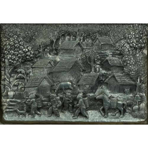 273 - Thai white metal plaque profusely decorated in relief with figures before a village, mounted and fra... 