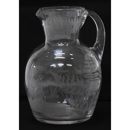 322 - Victorian glass water jug etched with ferns and a pipe smoking female sitting on a chamber pot, 14.5... 