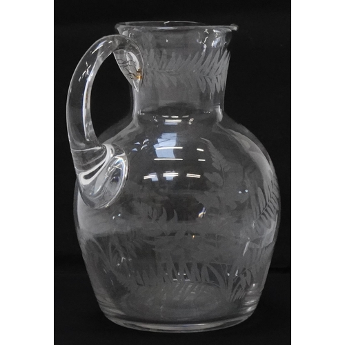 322 - Victorian glass water jug etched with ferns and a pipe smoking female sitting on a chamber pot, 14.5... 