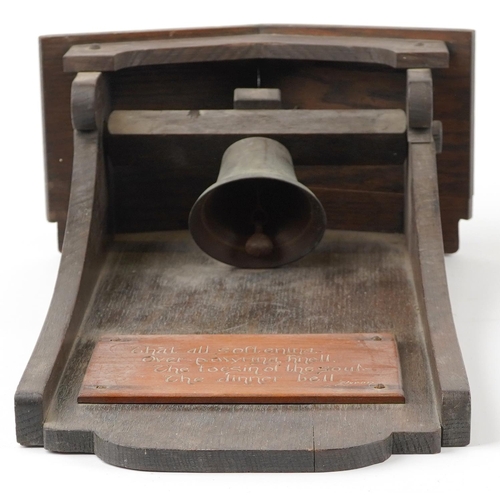 459 - Arts & Crafts oak dinner bell with applied plaque having incised Byron motto, 53cm high