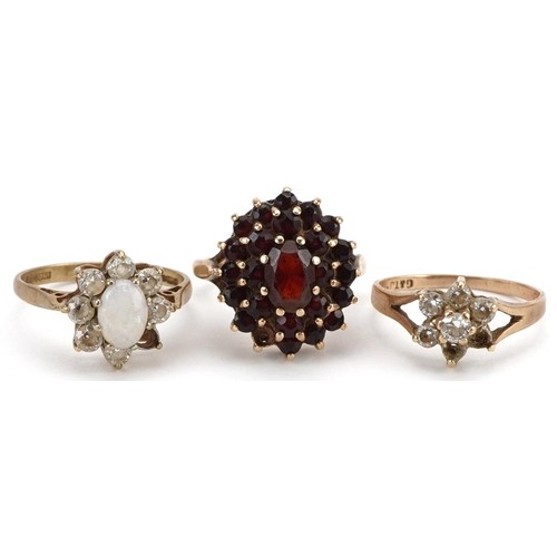 2554 - Three 9ct gold rings comprising Bohemian garnet three tier cluster, cabochon opal and cubic zirconia... 