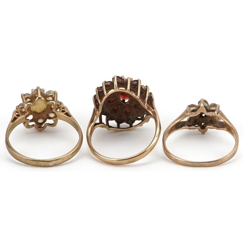 2554 - Three 9ct gold rings comprising Bohemian garnet three tier cluster, cabochon opal and cubic zirconia... 