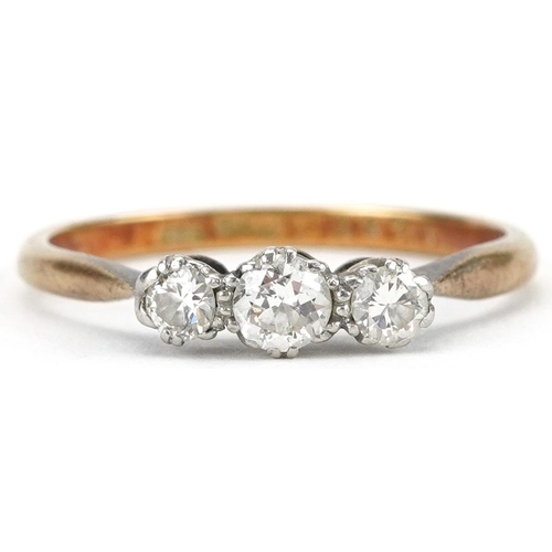 2067 - 18ct gold and platinum diamond three stone ring, the central diamond approximately 0.12 carat, size ... 