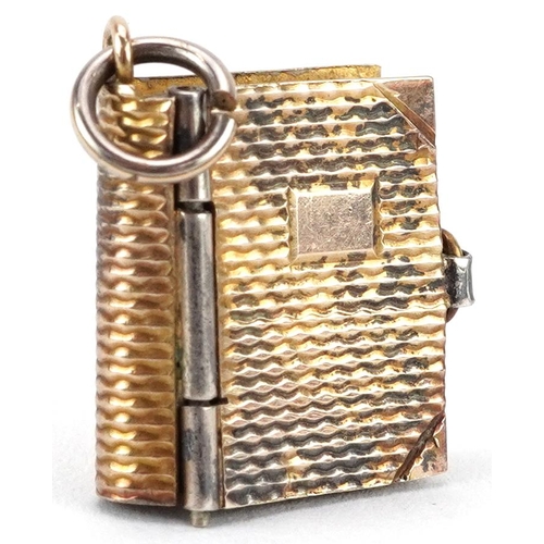 2523 - 9ct gold charm in the form of a book with London postcards, 1.5cm high, 2.3g