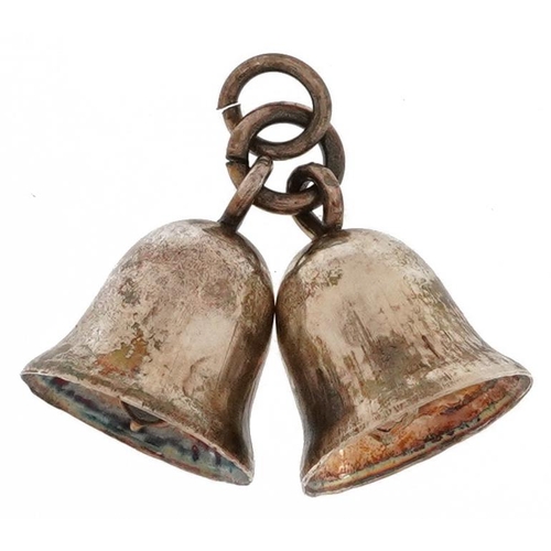 2518 - Unmarked silver charm in the form of two bells, overall 2.2cm wide, 1.6g