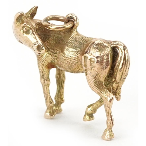 2110 - 9ct gold charm in the form of a standing horse, 2.4cm in length, 7.8g